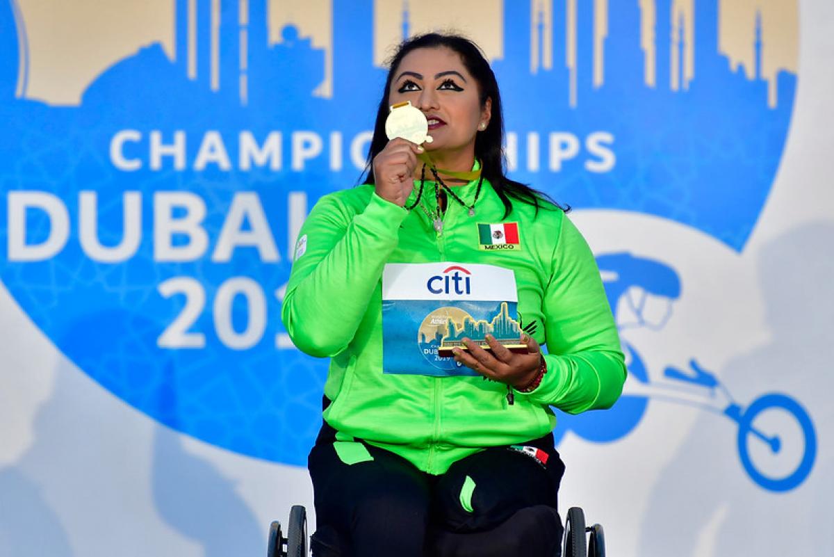 Image of a female Para Athletics in the podium with her gold medal