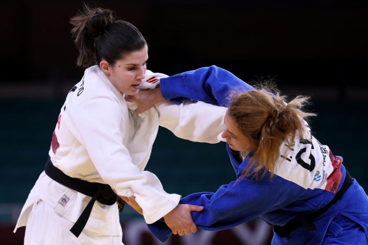 Two female judokas grapple in a competitive bout