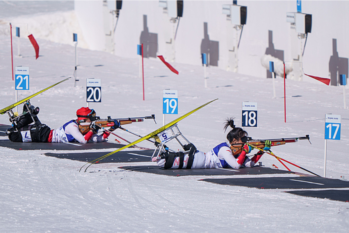 Two female athletes in a Para biathlon shooting range