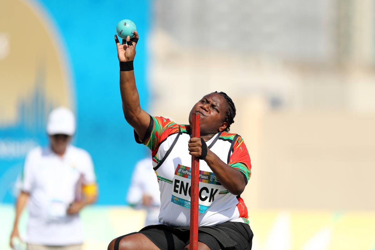 A woman about to make a throw in a seated shot put competition.