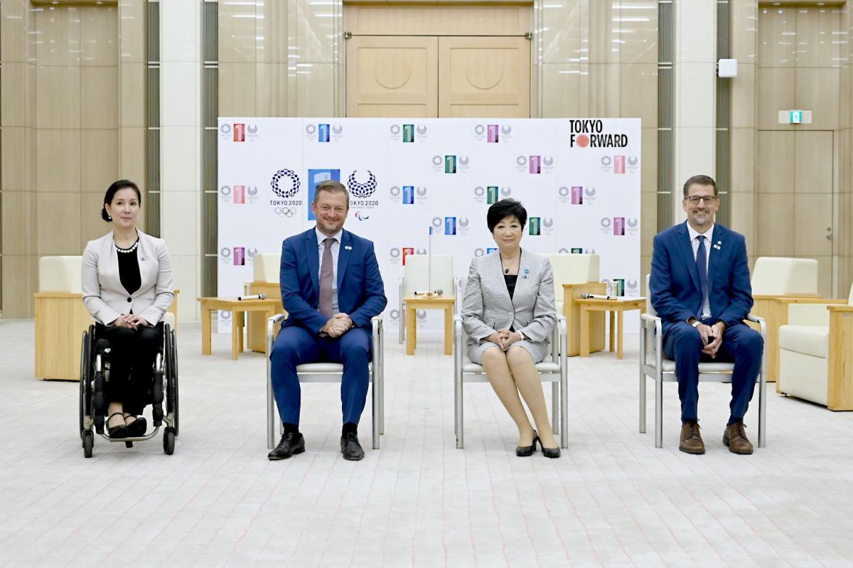 Four people in official attire, two men and two women, pose for a photo.