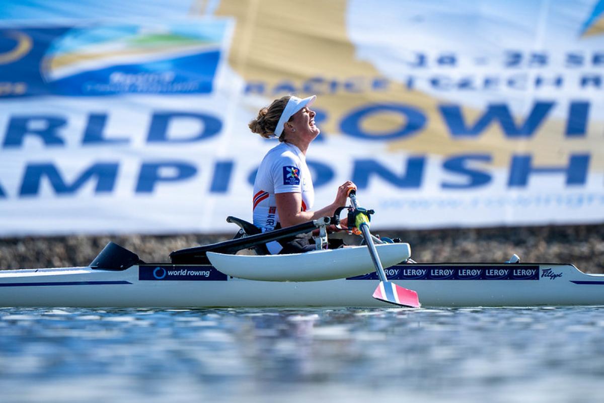 A side view of a female athlete on a rowing boat.