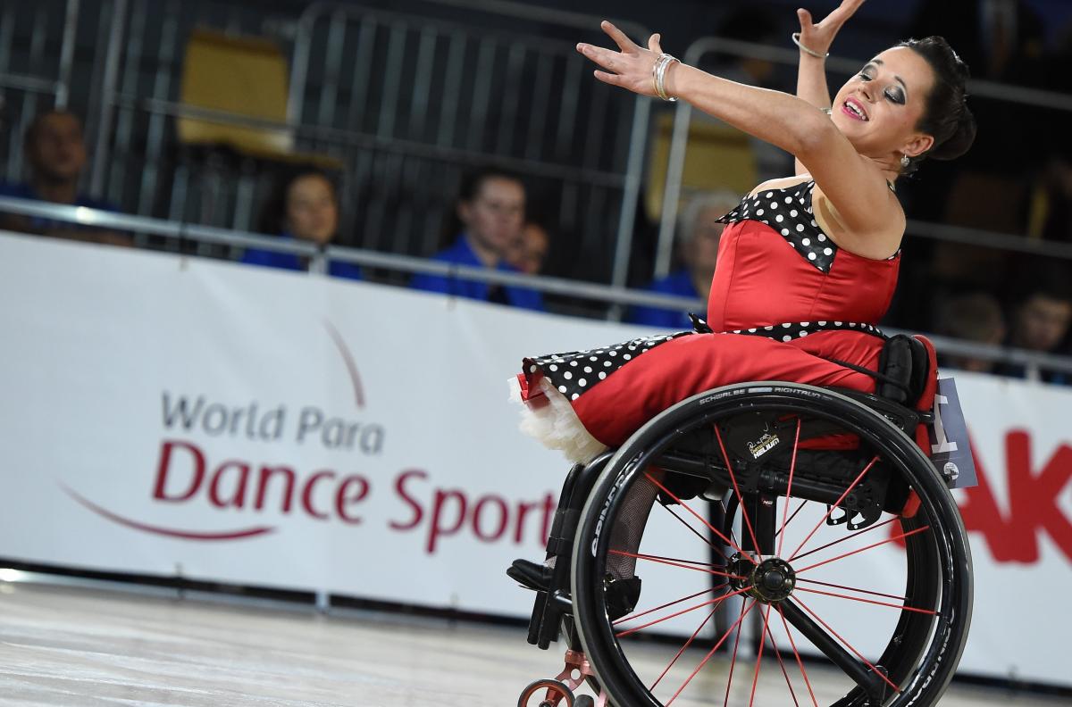 A female wheelchair dancer with a red dress during a competition