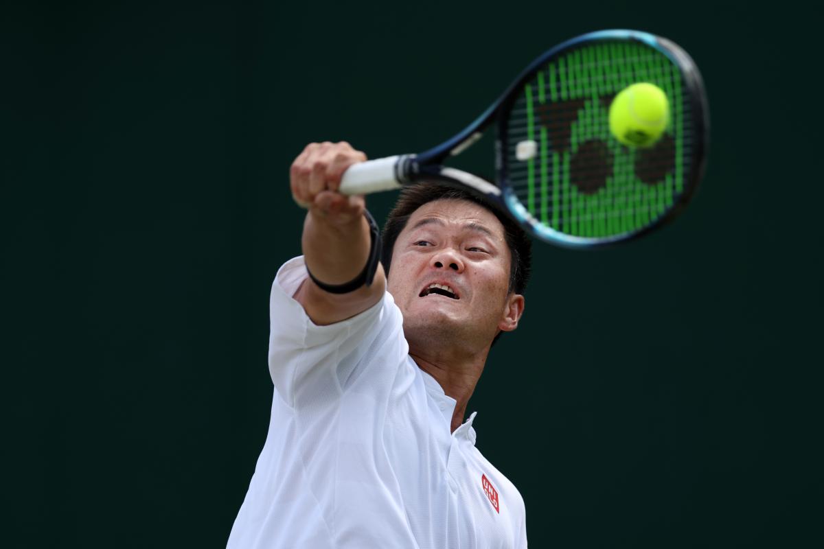 A closeup of a male tennis player as he plays a backhand during a wheelchair tennis tournament.