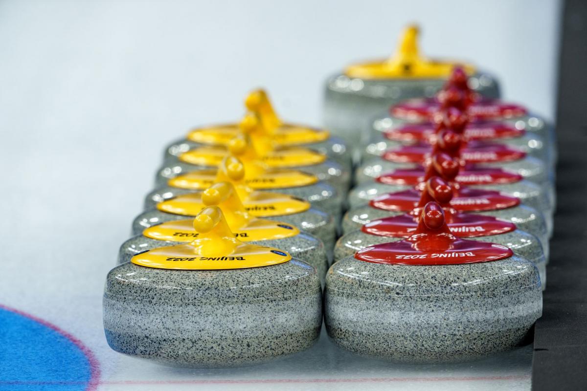 Two rows of Beijing 2022 curling stones marked on the ice.