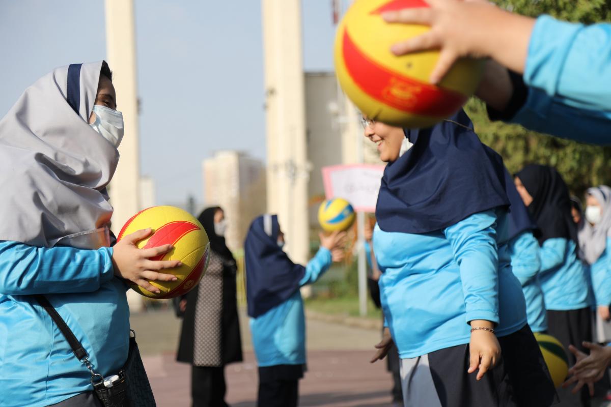 Teenage girls toss a ball as part of National Paralympic Day activities.