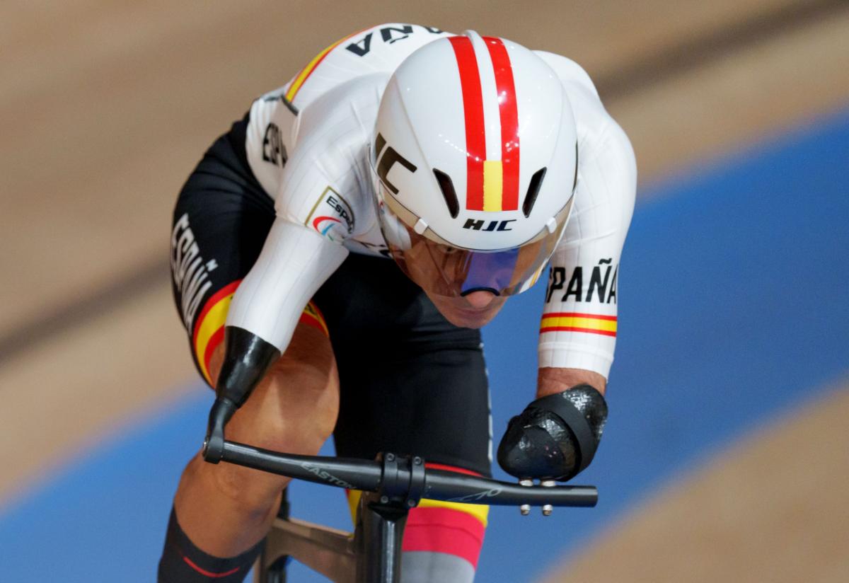 A male athlete wearing a helmet rides a bicycle at the Tokyo 2020 Paralympic Games.