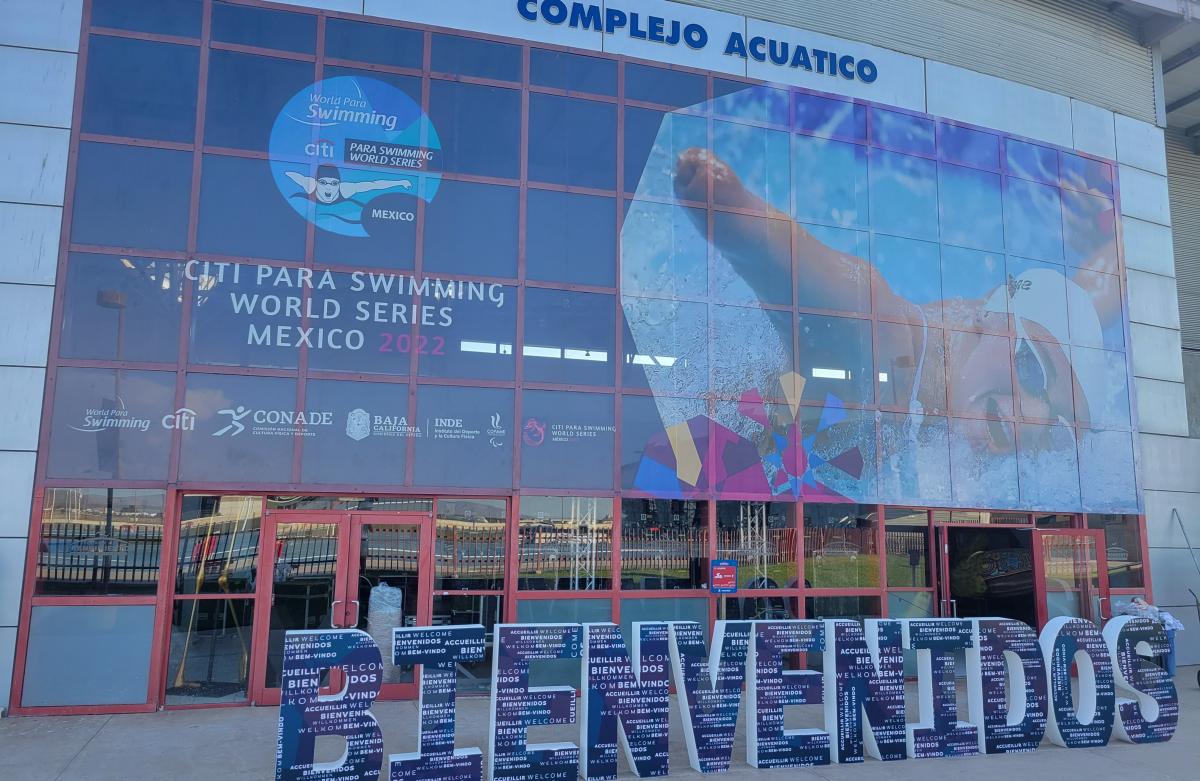 The entrance of an aquatics centre with the Bienvenidos message in front of the doors