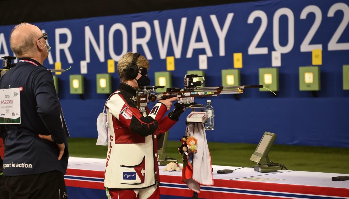 A female vision impaired shooter and her assistant in a competition