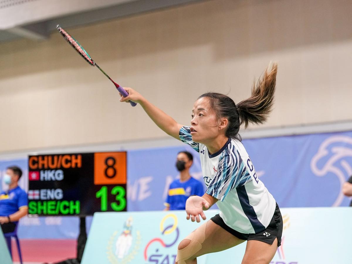 A female athlete plays badminton during a match.