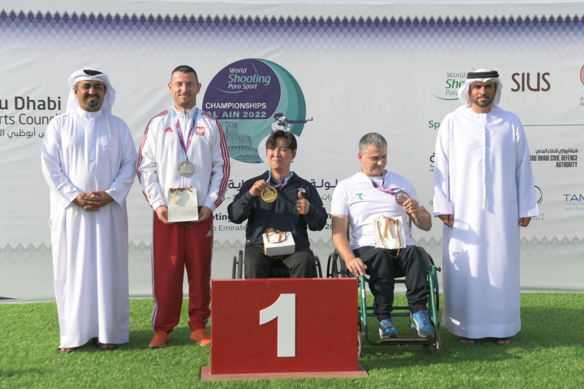 The medallists of P1- men's 10m air pistol SH1 poses with their medals on the podium of the Al Ain 2022 World Shooting Para Sport Championships.