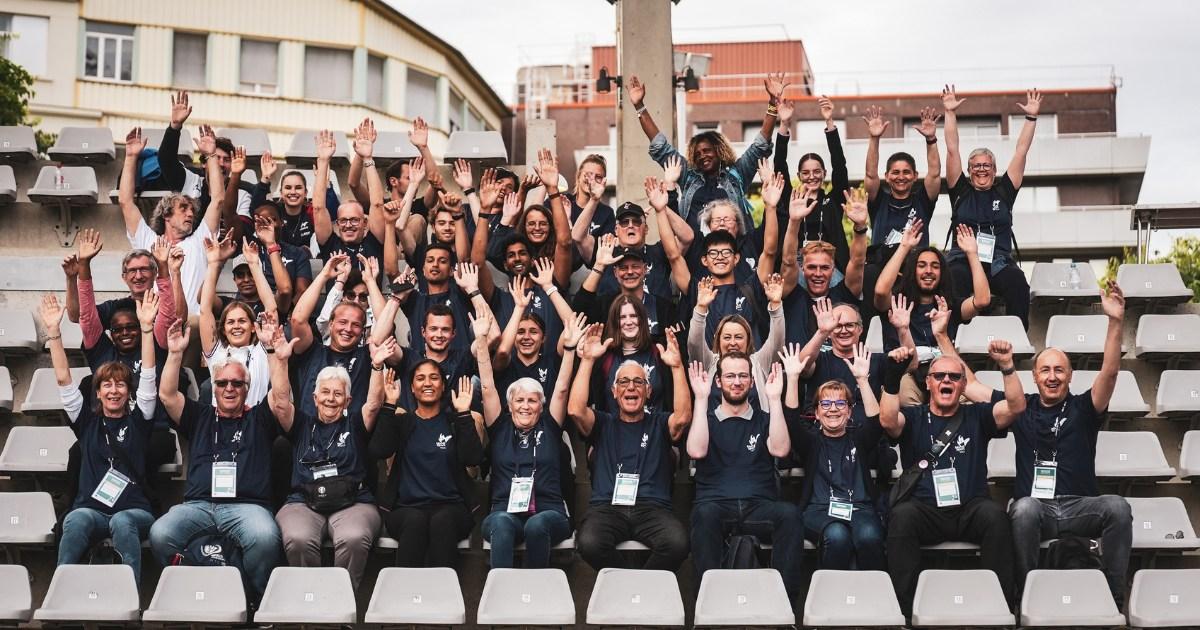 A group of people waving from a stadium stand