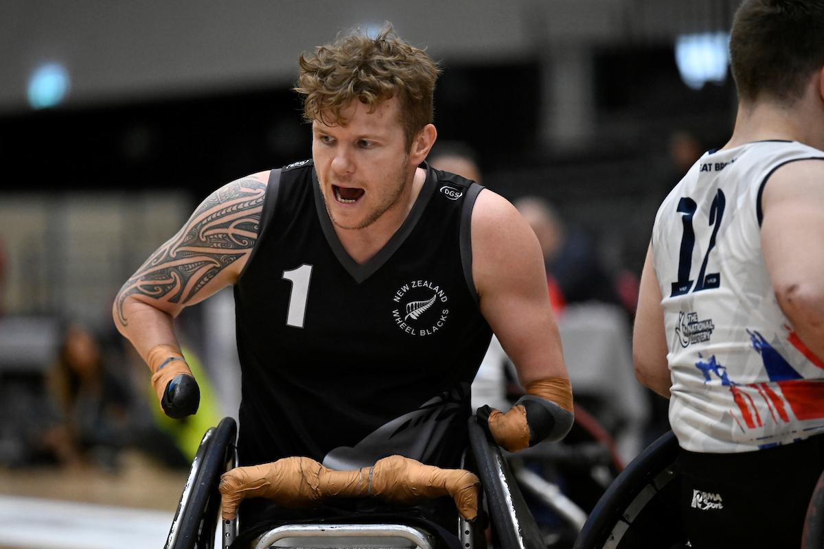 A male athlete wearing a black jersey competes at the 2022 Wheelchair Rugby World Championships