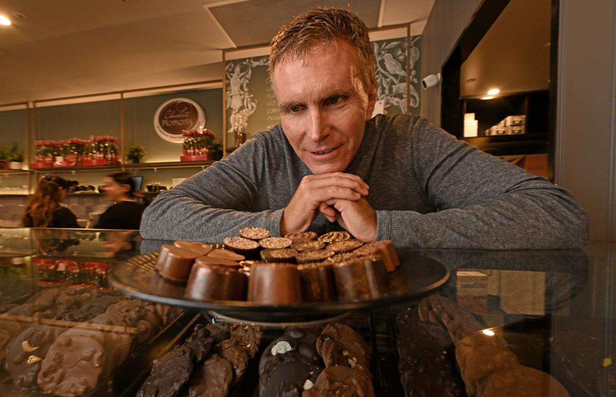 A man stands in front of a display of chocolates