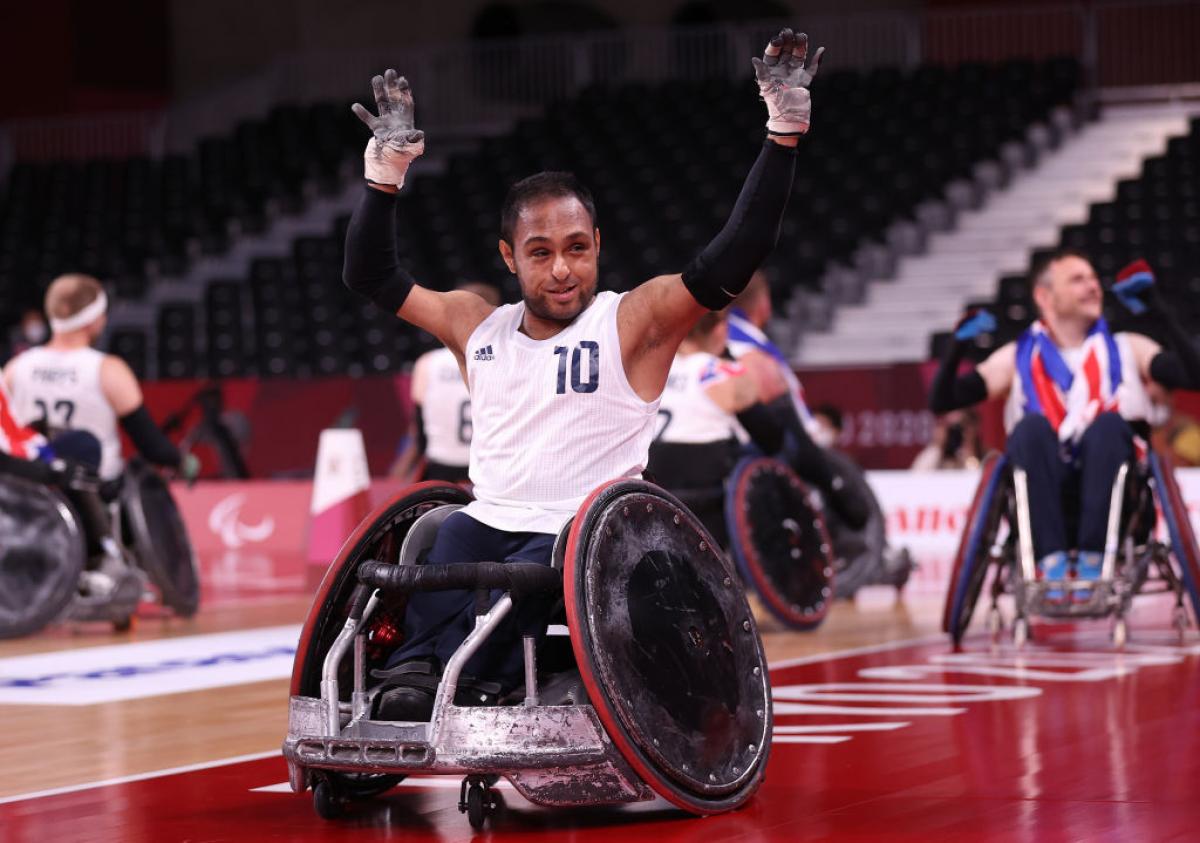 A male wheelchair rugby player raises both hands in celebration at the Tokyo 2020 Paralympic Games.