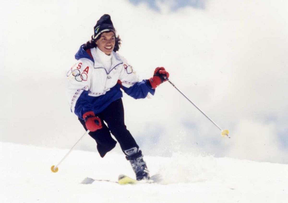 A female Alpine skier wearing a Team USA jacket skis