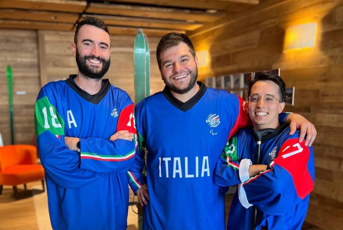 Three men wearing Italy's Para ice hockey jersey posing for a picture