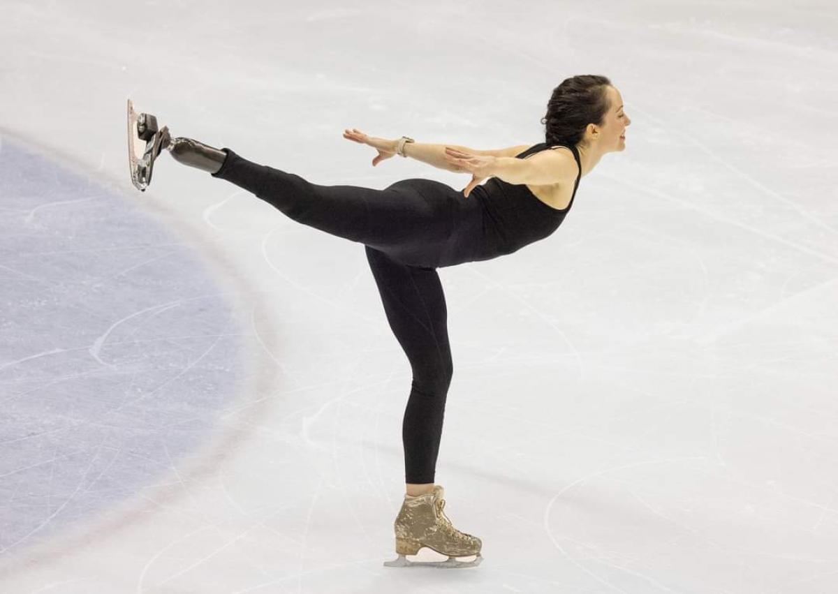 A female athlete with a prosthetic leg skates.