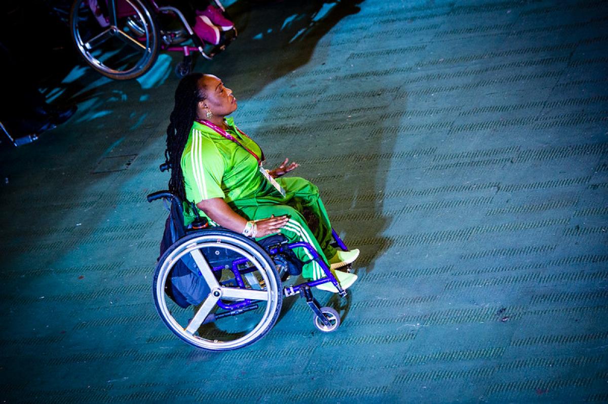 A woman in a wheelchair with a green Nigerian shirt