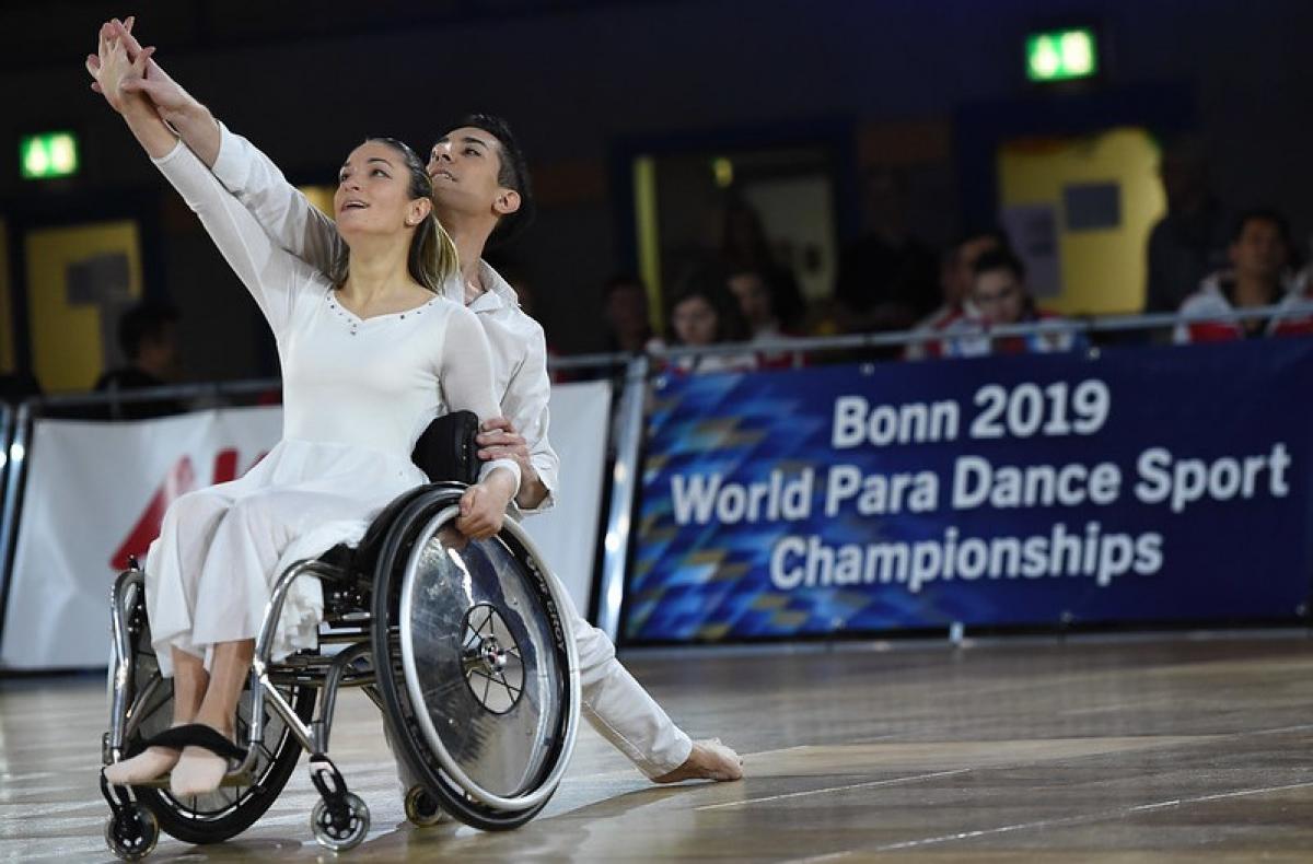 A woman in a wheelchair and a male partner in a dance competition
