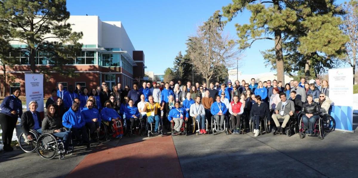 A group of about 80 people pose for a photograph.