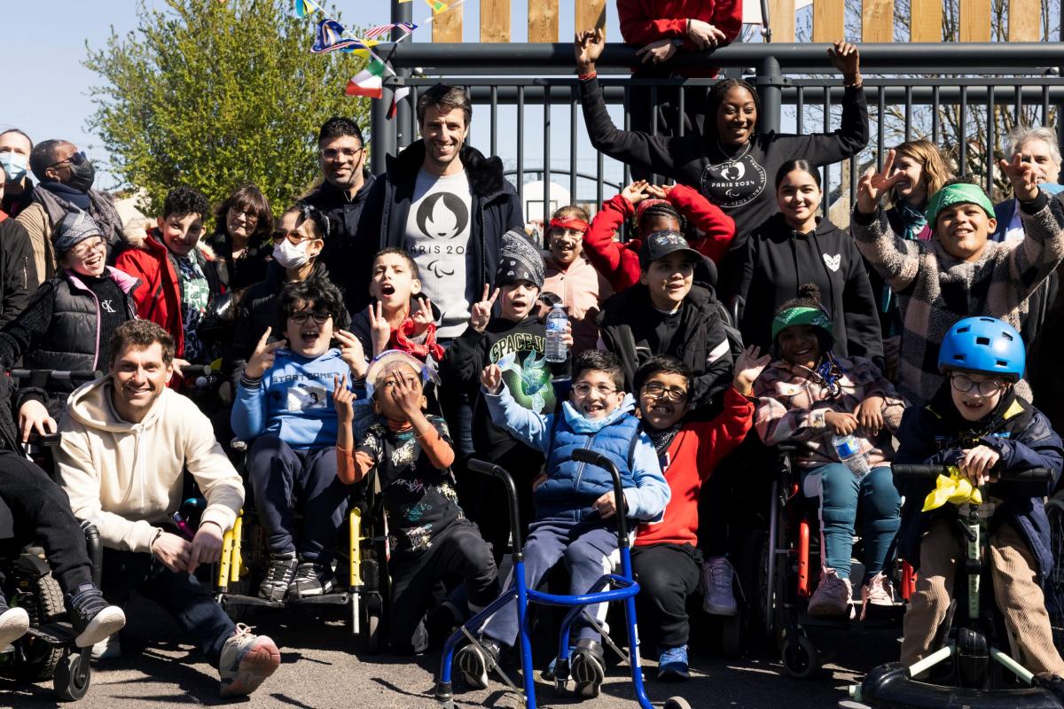 A group photo of about 20 people, including children using wheelchairs
