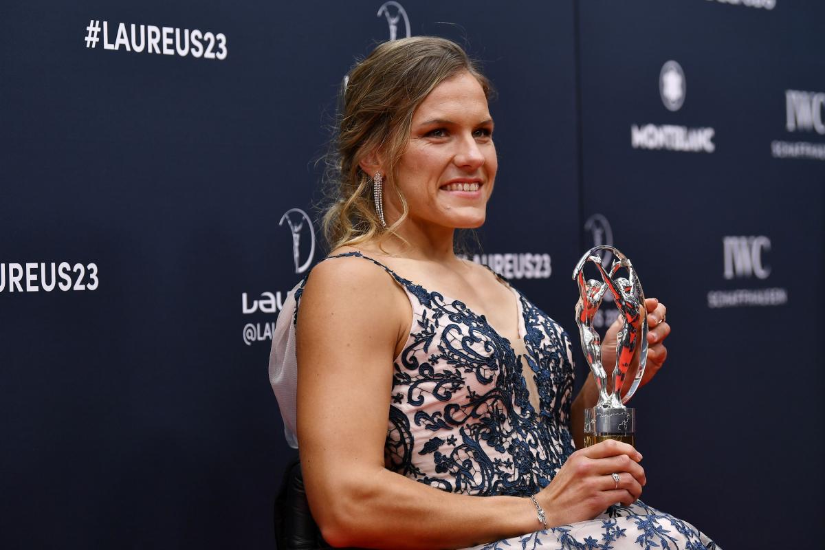 A female athlete holds a silver trophy