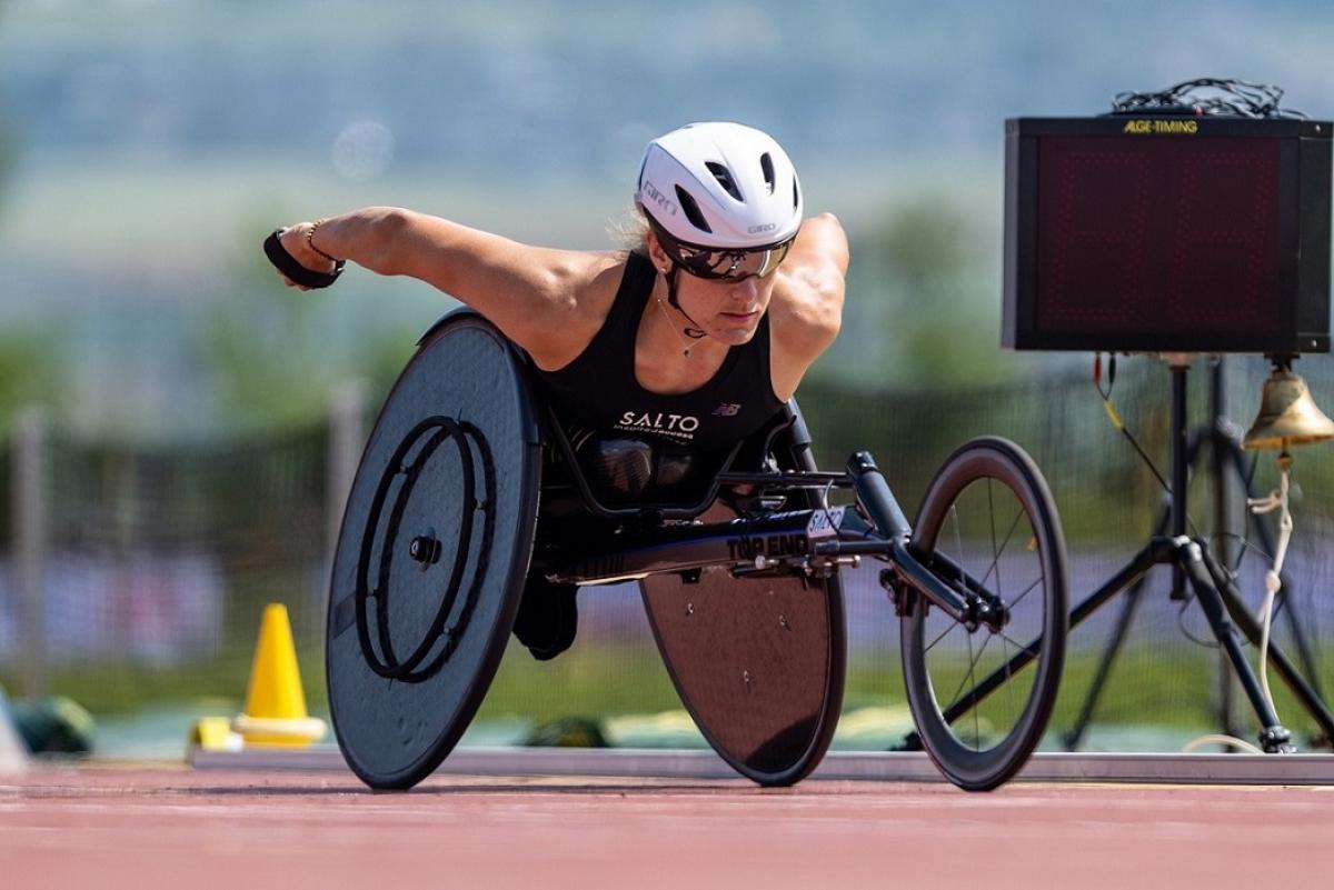 A female wheelchair racer on a red athletics track