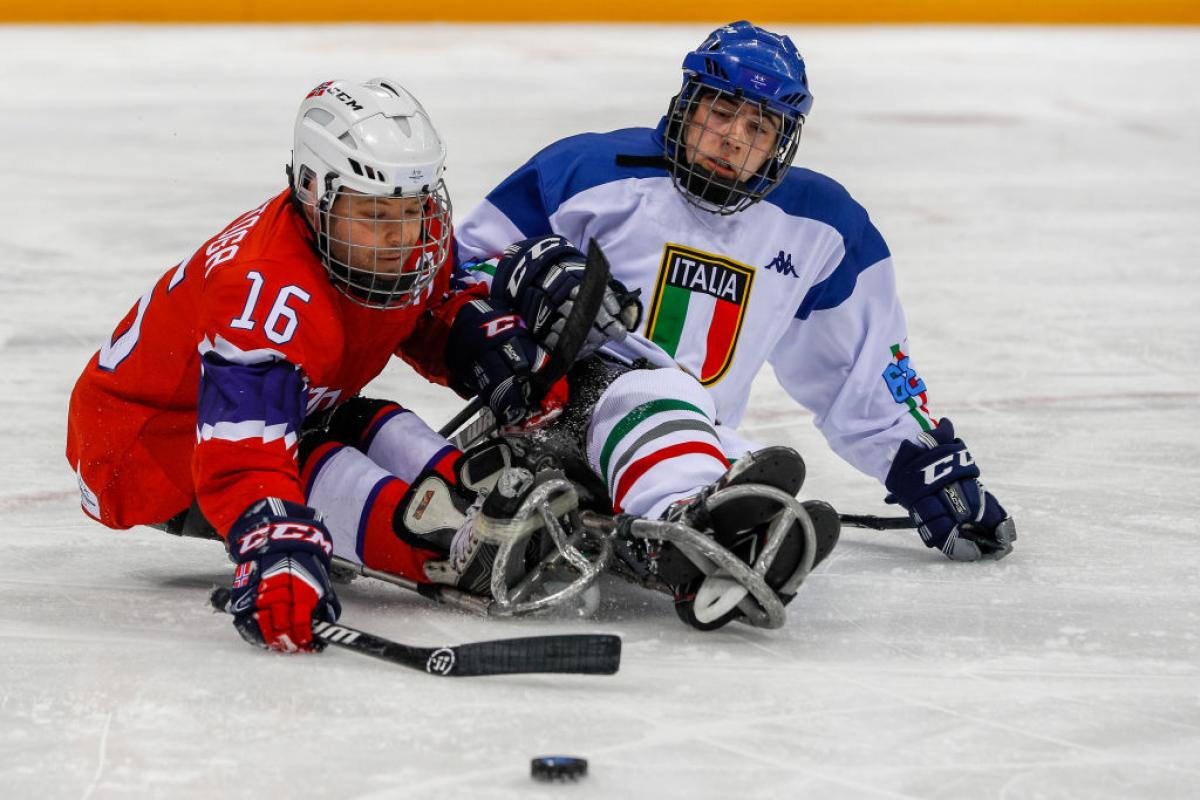 Two male Para ice hockey players competing on ice