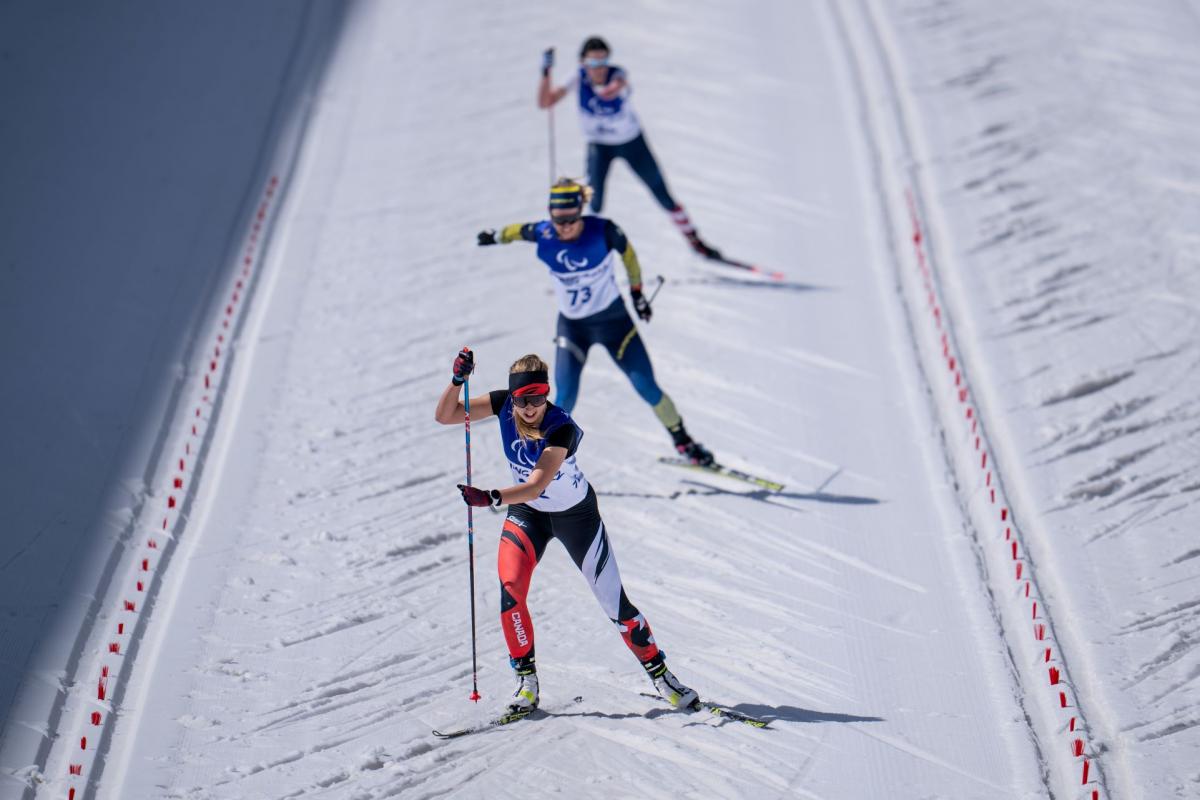 Three female cross-country skiers compete at Beijing 2022.