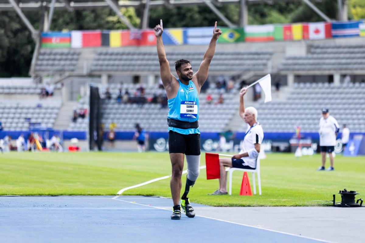 A men with a prosthetic leg celebrating on an athletics track