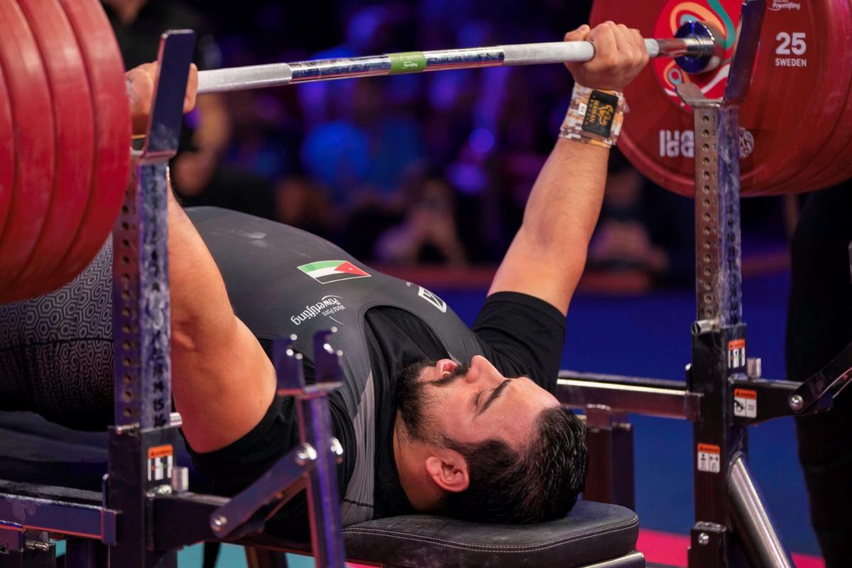 A man lifting a bar on a bench press