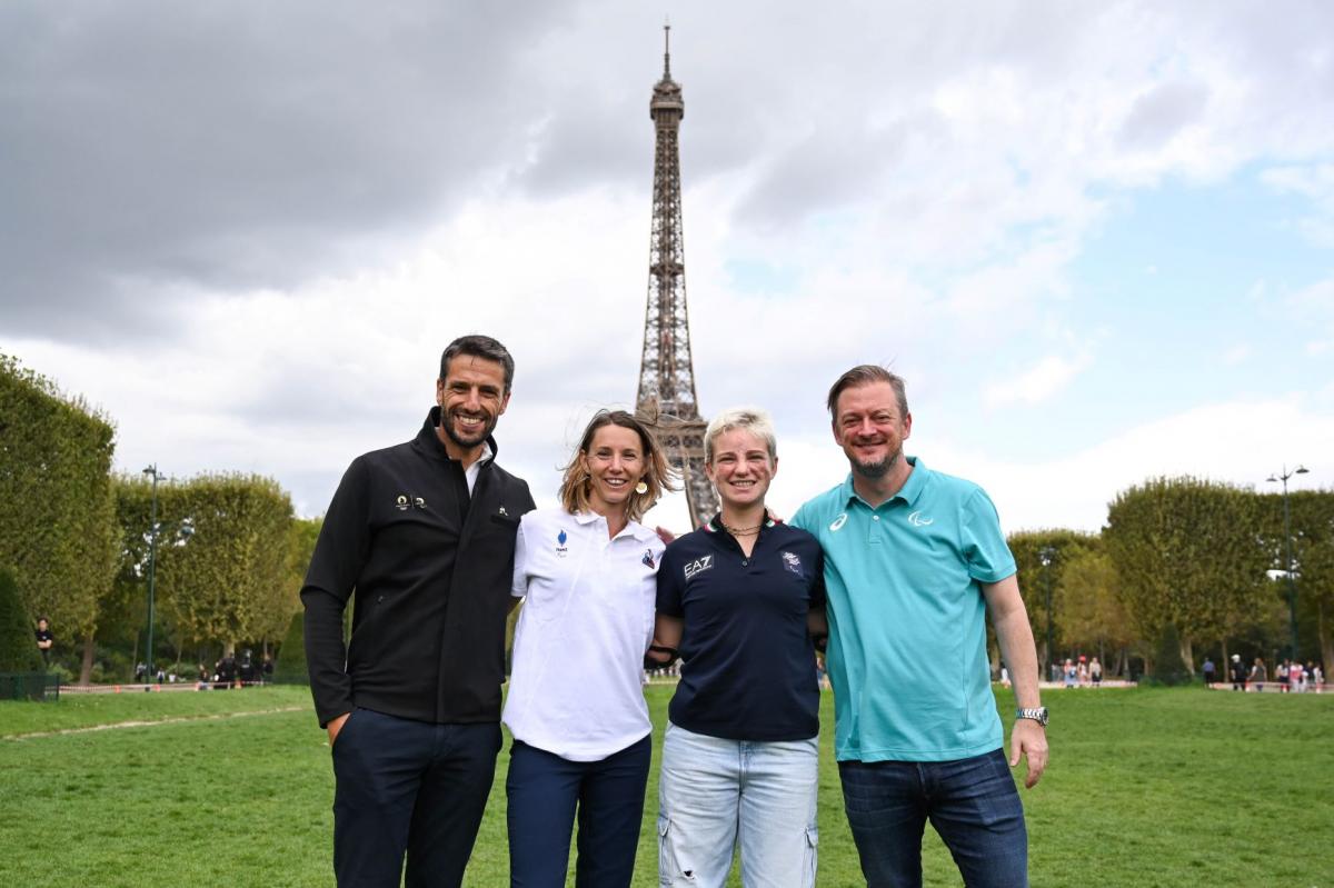 Four people pose for a photo in front of the Eiffel Tower