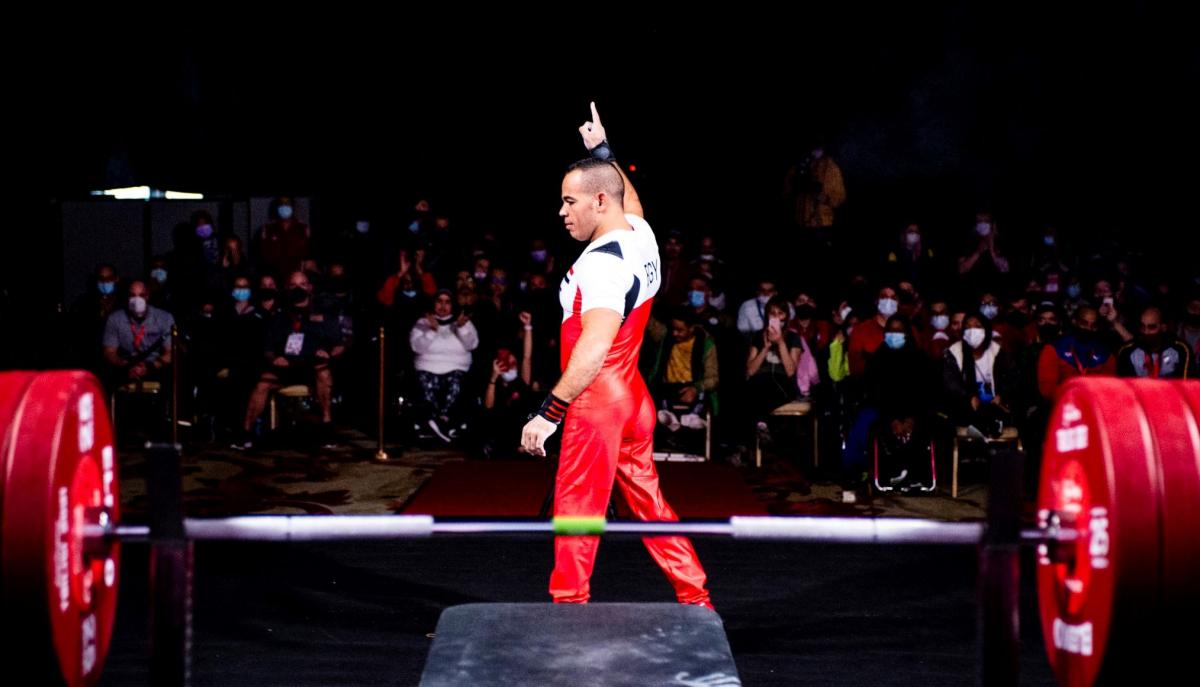 A male powerlifter standing in front of the crowd during a competition