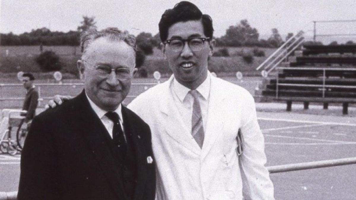 Black and white photo of Japanese man posing with Sir Ludwig Guttman