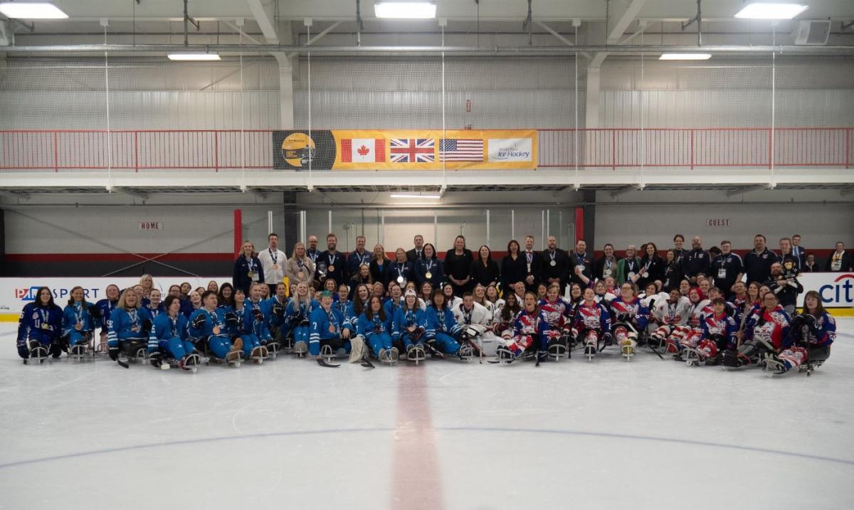 Four women's Para ice hockey teams posing for a picture on an ice rink