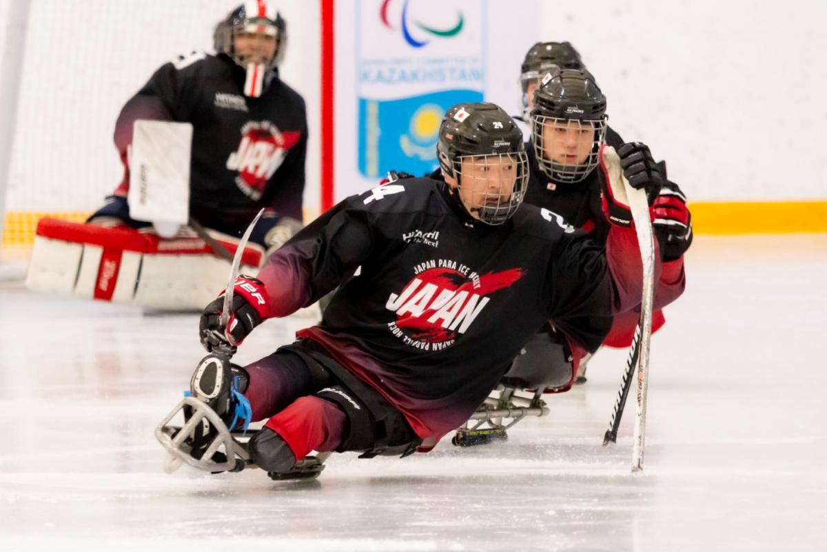 Three Japanese Para ice hockey players during a game