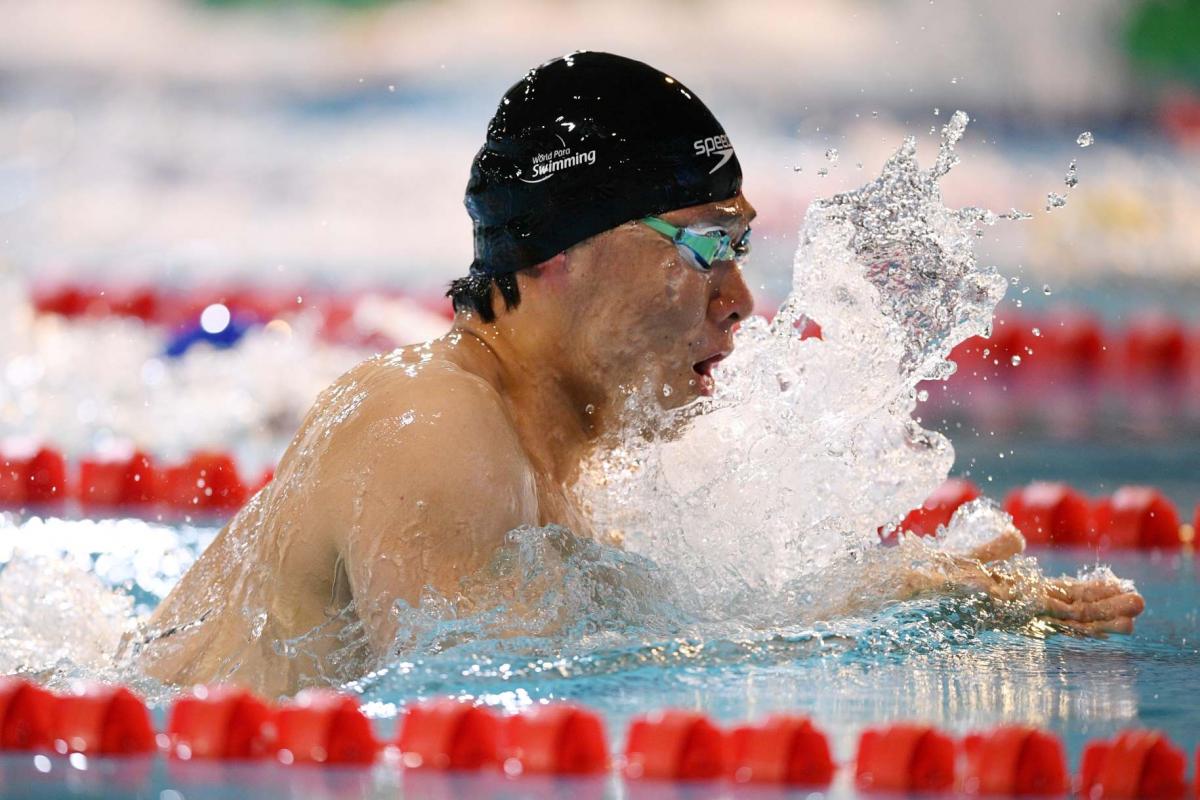 A male swimmer in a breaststroke race