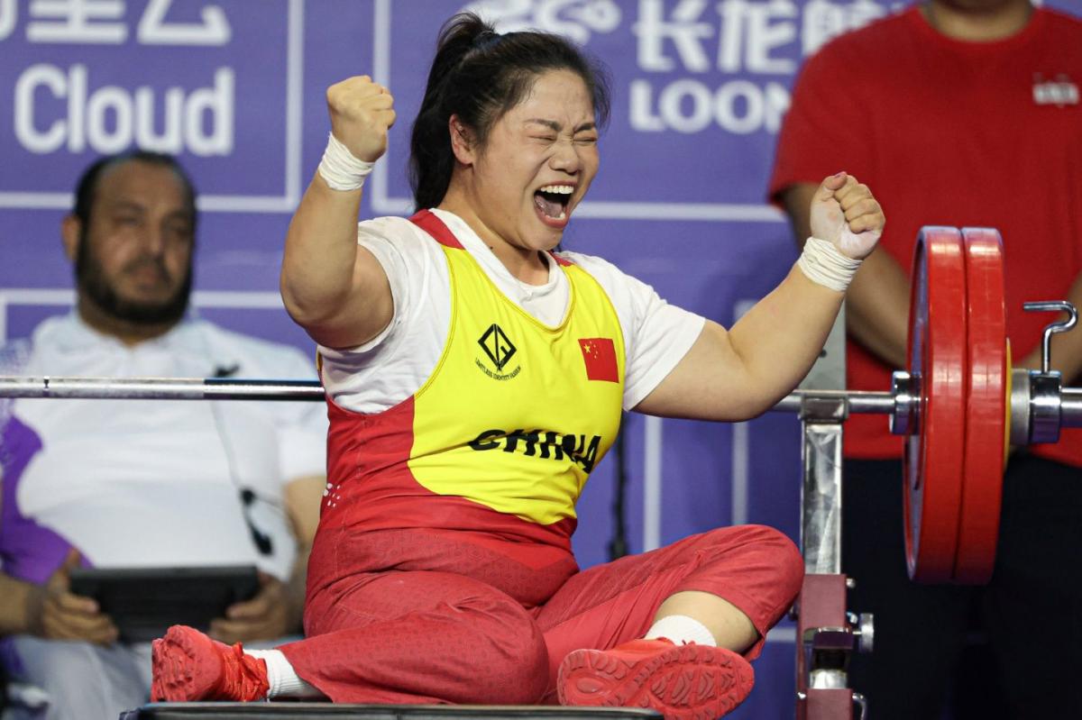 A female powerlifter celebrating on a bench press