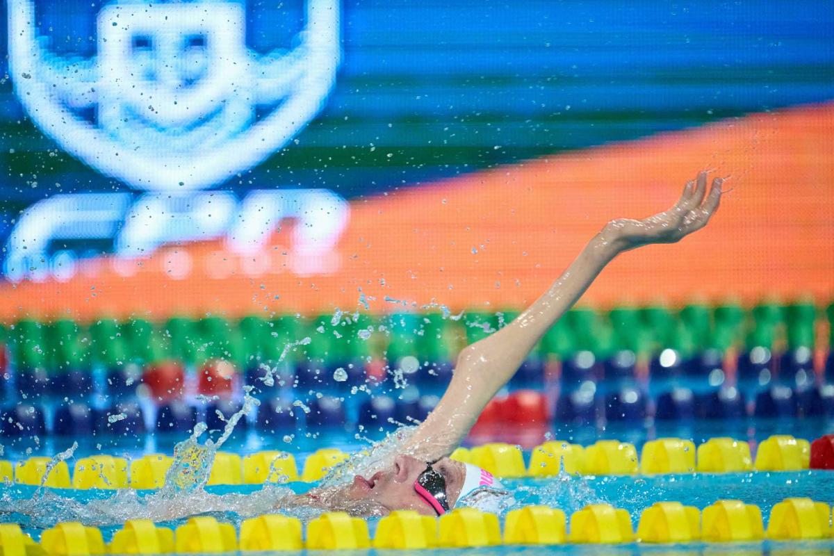 A male swimmer with a disability in his right arm in a swimming pool 