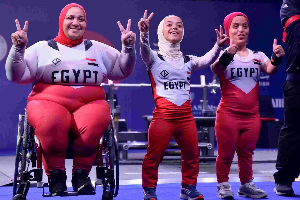 Women powerlifters celebrate.