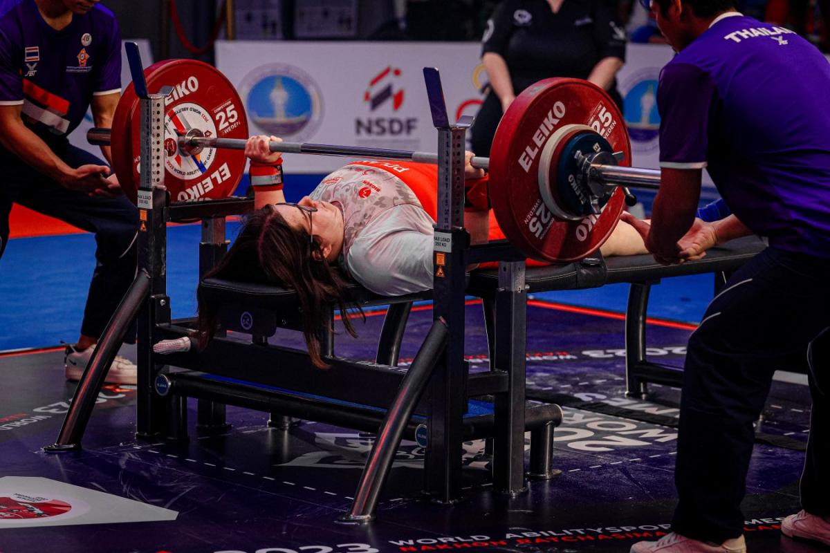 A woman on a bench press in Para powerlifting competition