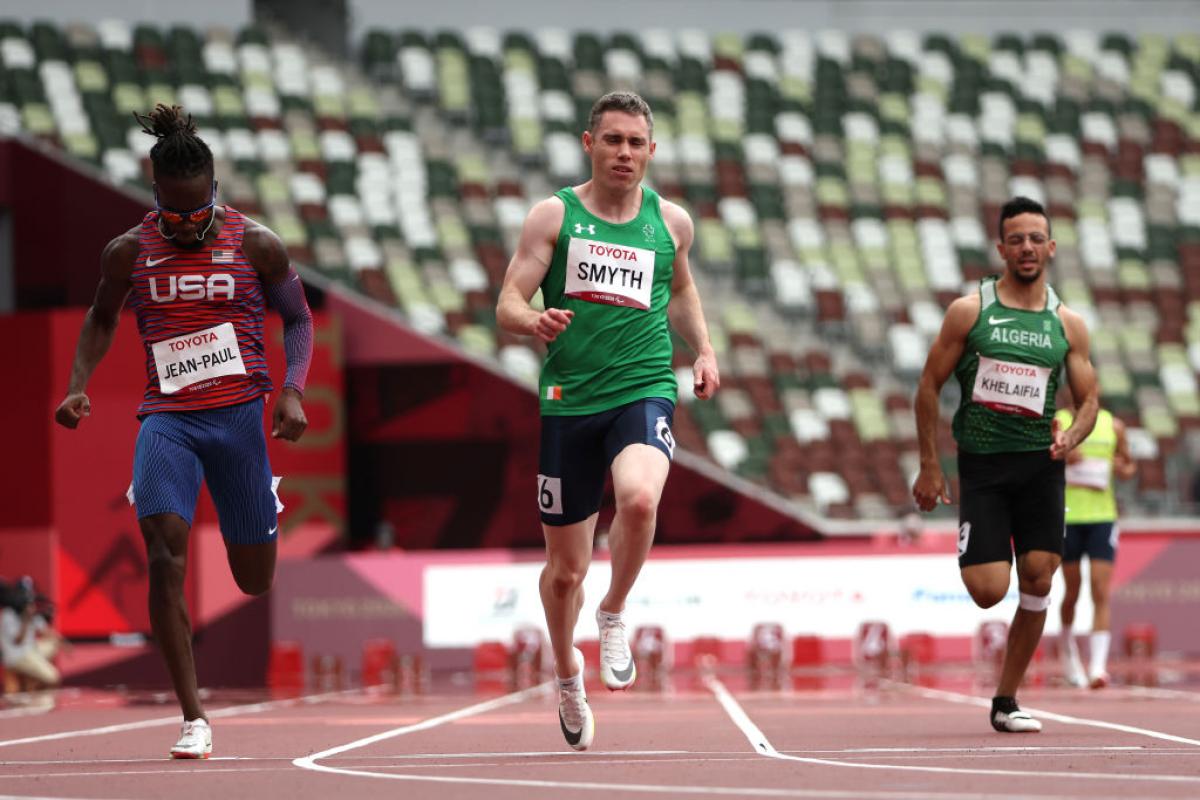 Three male athletes compete in a race.