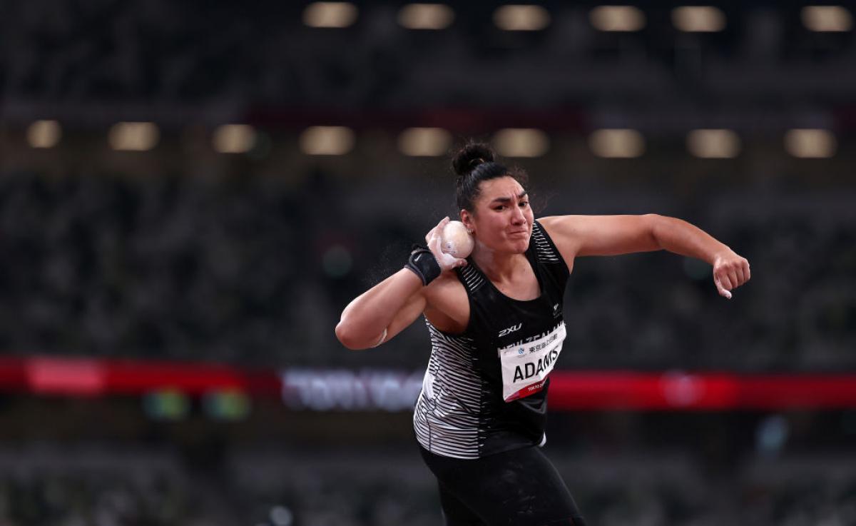 A female shot put athlete competes in a stadium