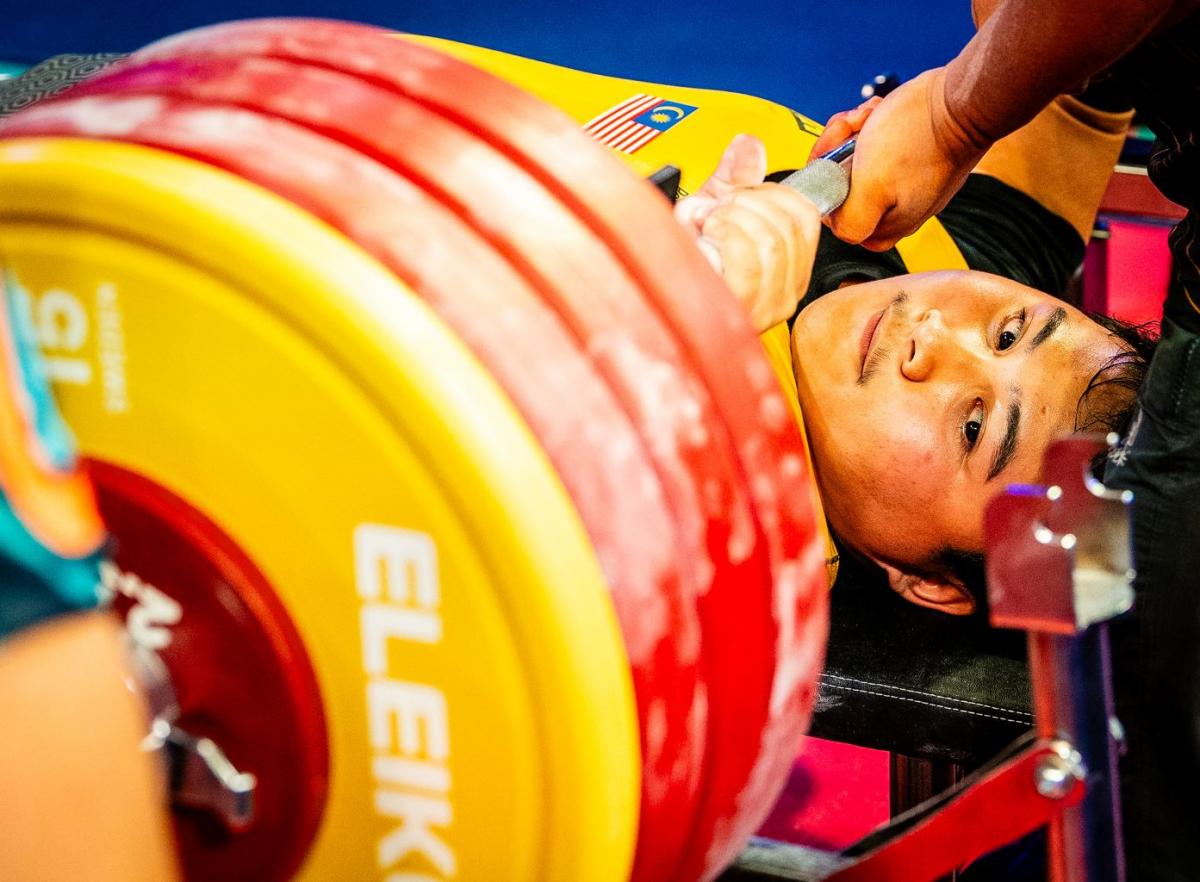 A man on a bench press looking at the discs