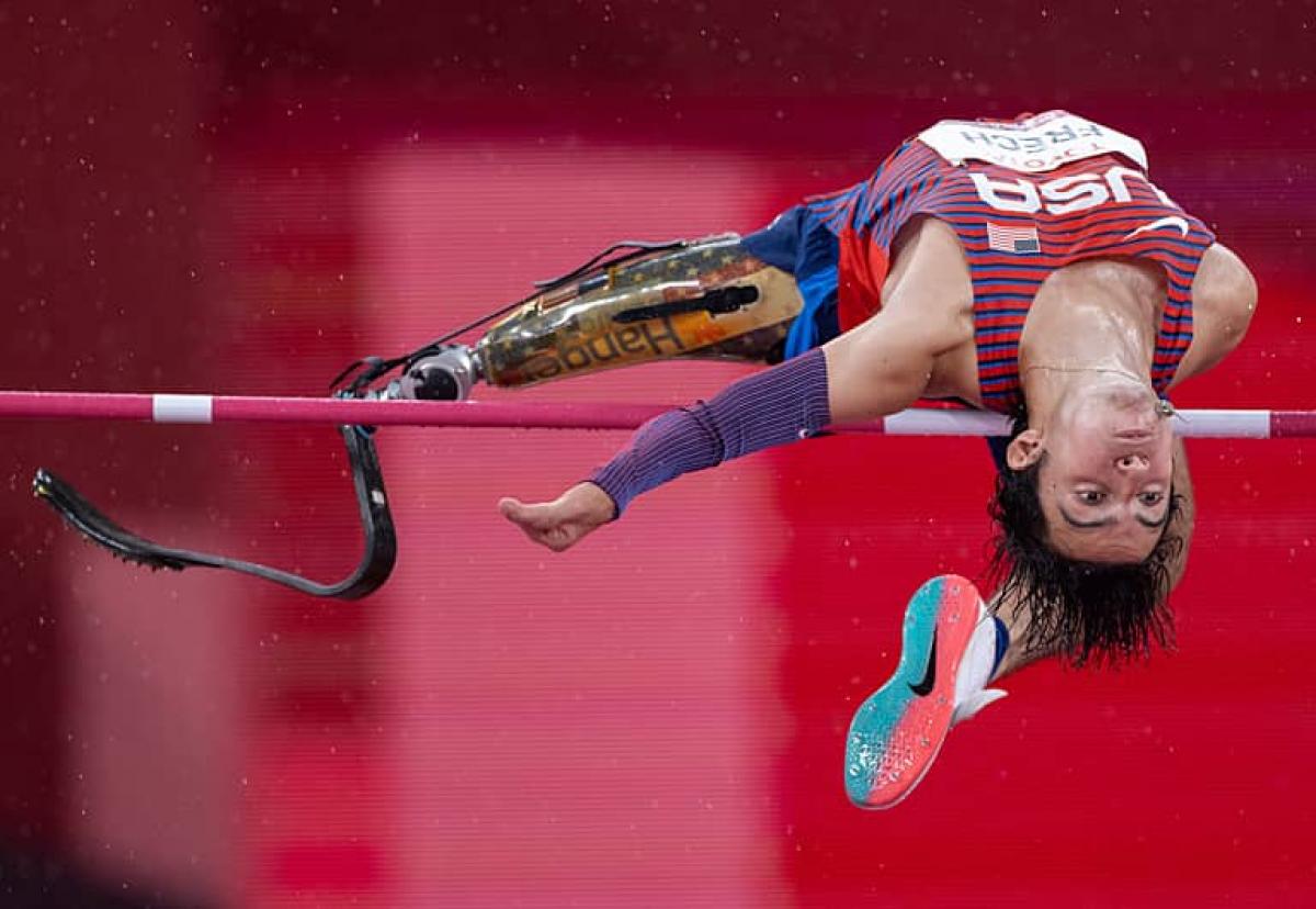 Ezra Frech jumps backwards over the high bar displaying his prosthetic leg