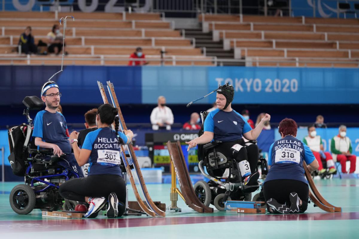 Two boccia athletes are competing in a match at Tokyo 2020 with their sport assistants.