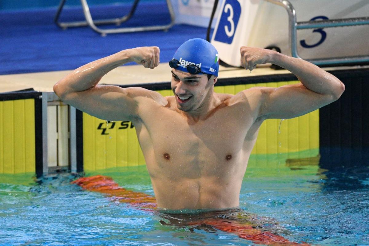 A male swimmer showing his arms in the pool