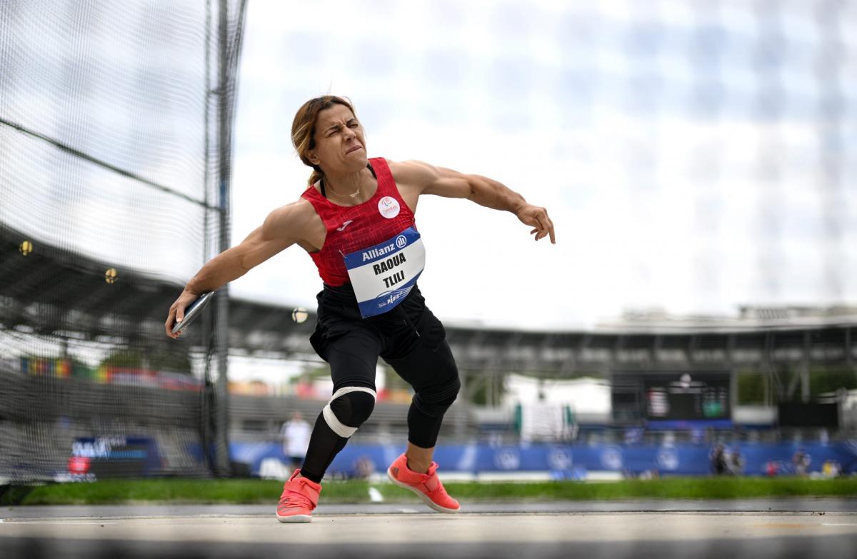 A short stature woman competing in the discus throw