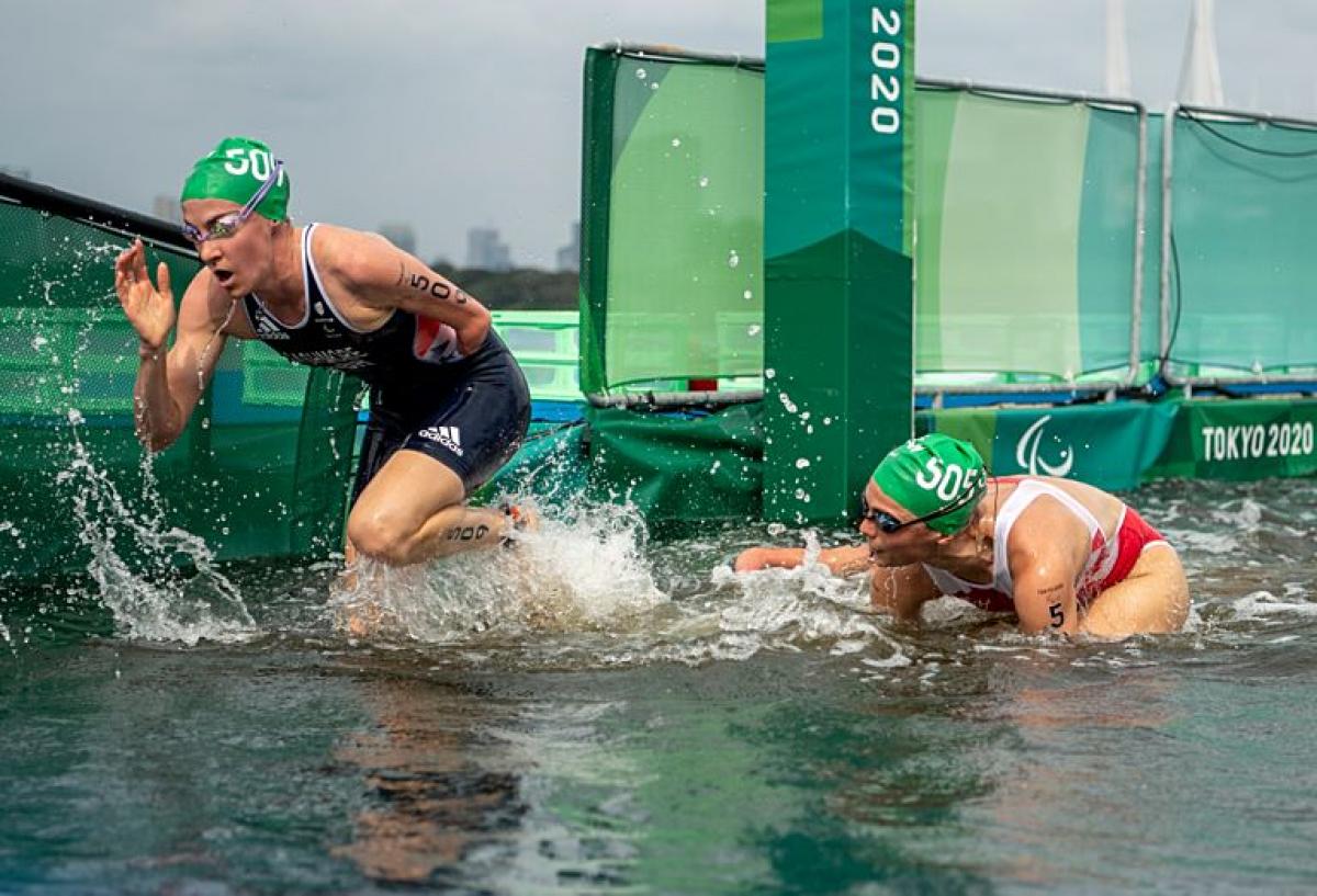 Two female Para triathletes are exiting the water